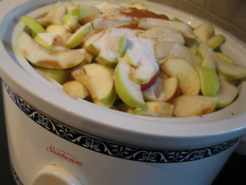Cut apples in a large crockpot with sugar, lemon, and spices.