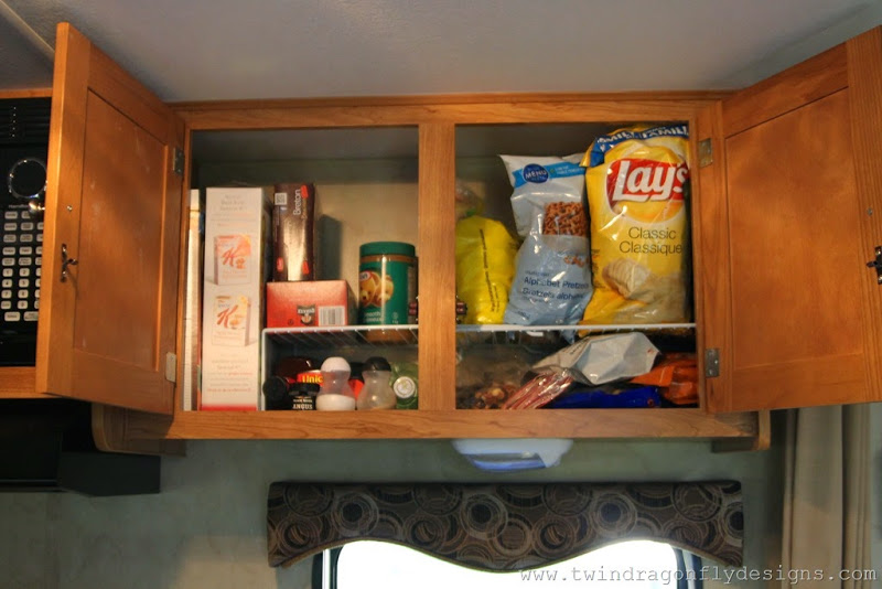 Wire dish organizers give two levels for dry goods in Travel Trailer cupboards.