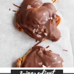 Three chocolate date bites are covered in a rich chocolate layer and sprinkled with sea salt, elegantly arranged on parchment paper. Text reads, 3-ingredient date bites recipe from homemedeheather.com.