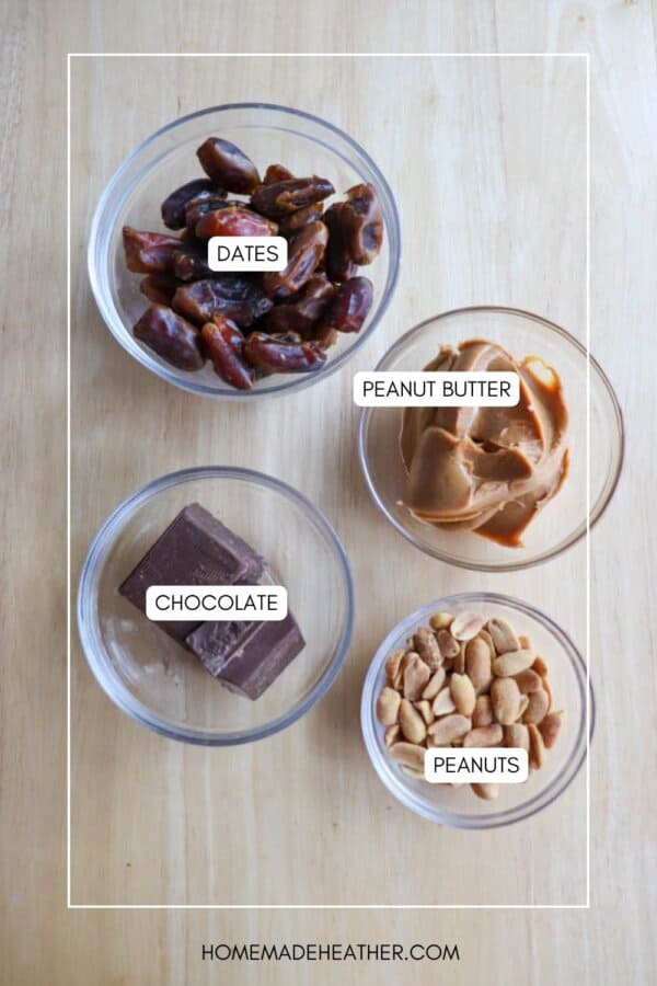 Four bowls on a wooden surface hold ingredients for chocolate coconut date bars, labeled as dates, peanut butter, chocolate, and peanuts. The neat arrangement features text overlaid on a light wood background.