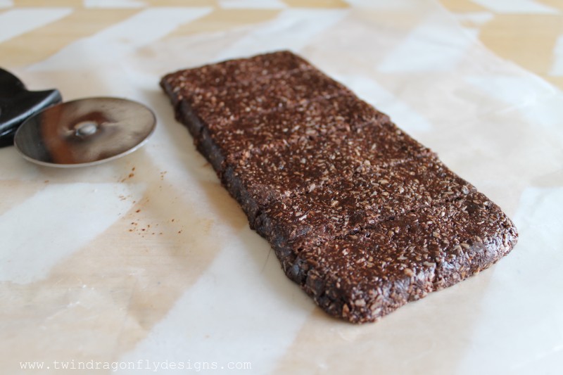 Chocolate Coconut Date Bars cut on parchment paper.