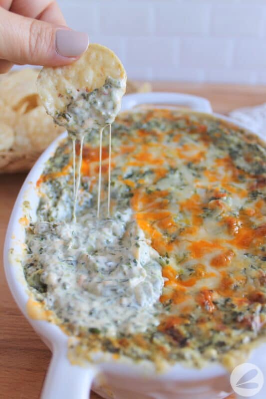 A tortilla chip dipped in then baked spinach dip.