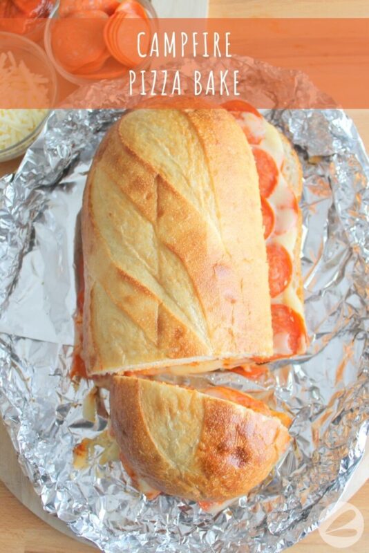 French loaf of bread on foil with pizza sauce, pepperoni slices and mozzarella cheese melting out around the edges.