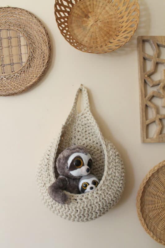 A crochet basket hanging on a wall.