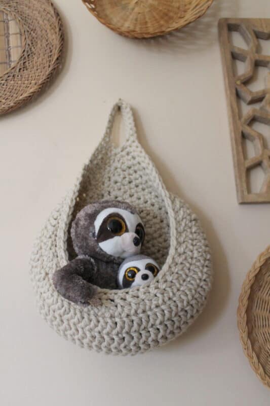 Small stuffed toys in a crochet hanging basket.