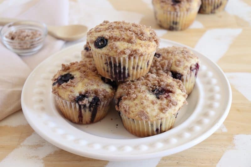A white plate with a stack of five Saskatoon berry muffins.