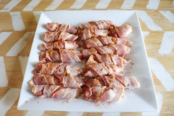 Chicken tenders wrapped in bacon before cooking.
