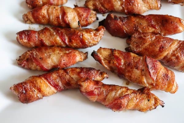 Bacon wrapped chicken tenders on a plate.