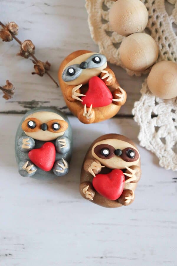 Clay Sloth holding a heart magnet craft.