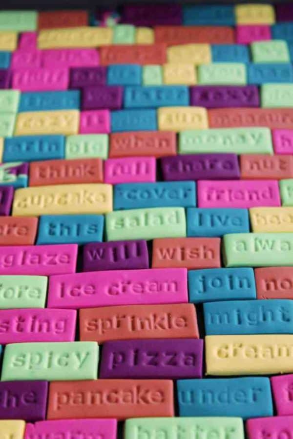 Colorful clay magnets with stamped words.