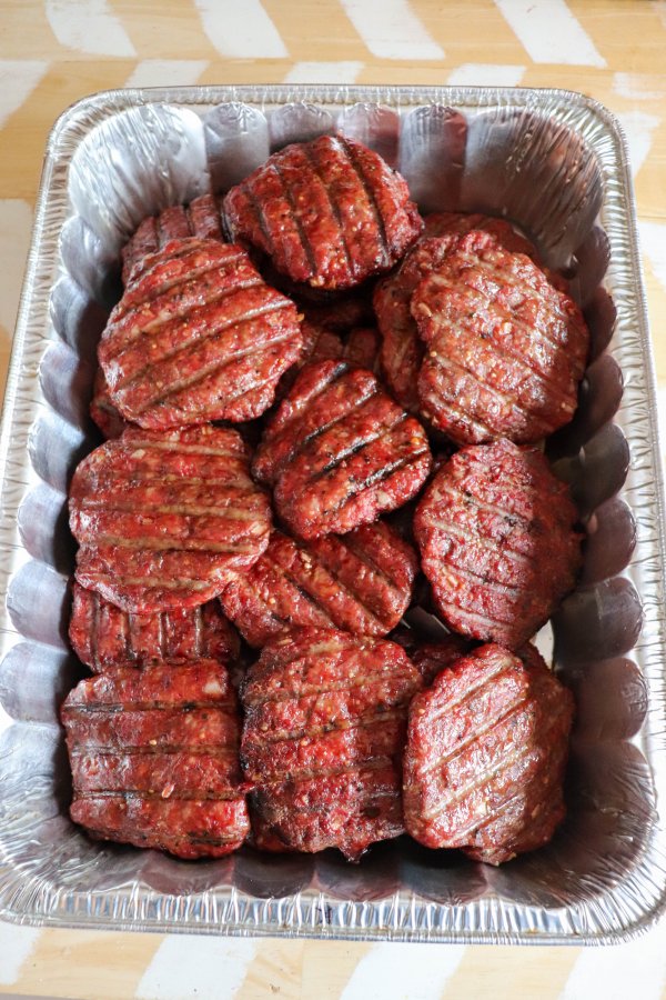 Cooked smoked burgers with grill lines piled on top of each other.