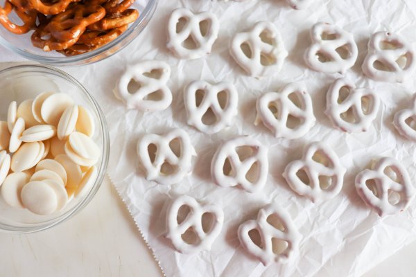 White chocolate covered pretzels on parchment paper.