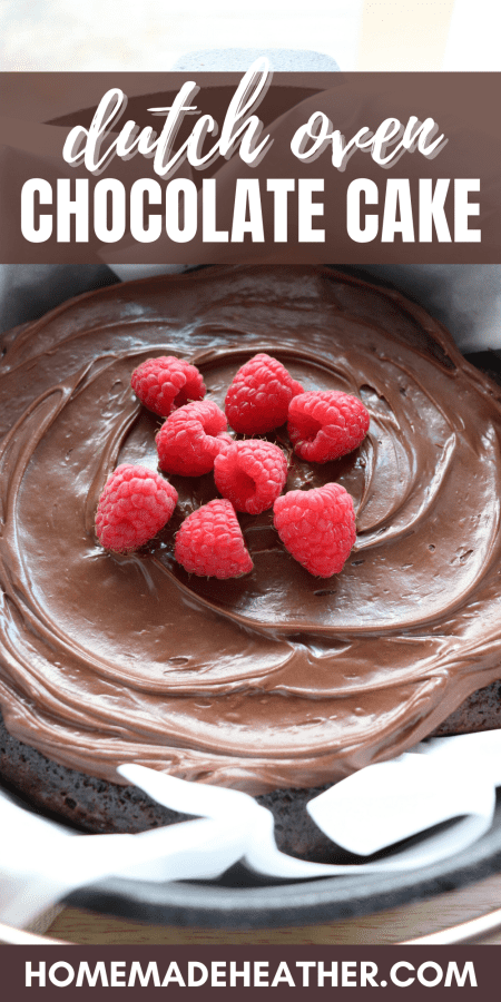 Close up of dutch oven chocolate Cake with chocolate frosting topped with fresh raspberries in a parchment paper lined cast iron dutch oven with text overlay.