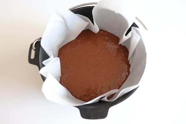 Chocolate cake mix in a parchment paper lined dutch oven.