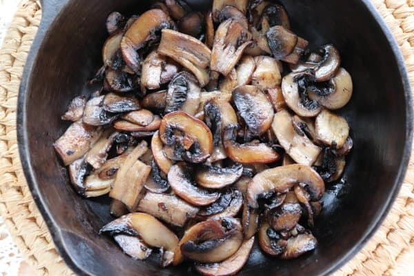 skillet philly cheesesteak recipe Sliced white mushrooms fried in a cast iron skillet.