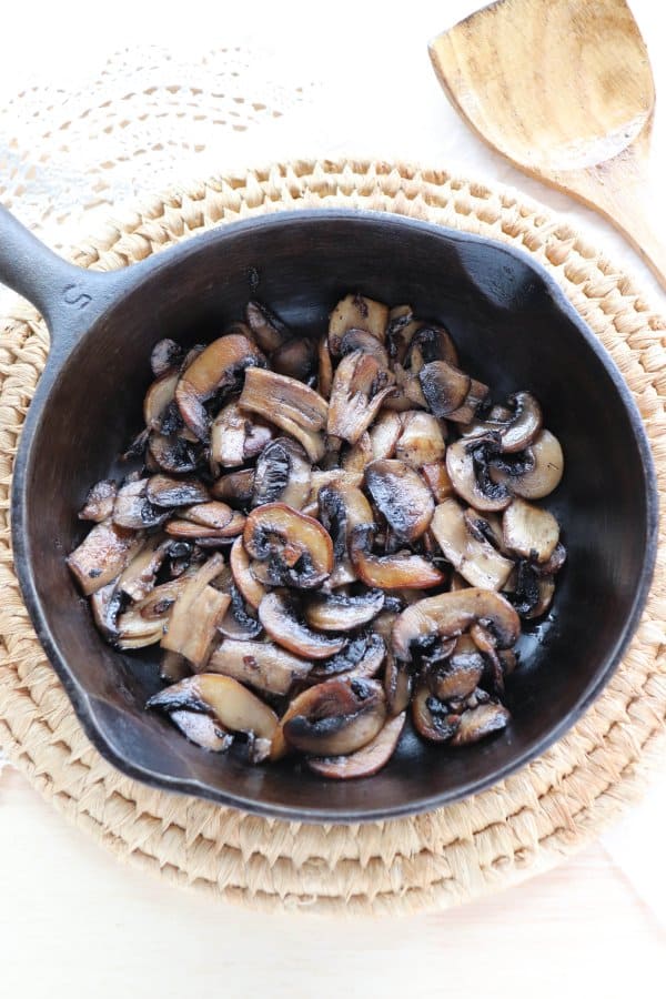 skillet philly cheesteak Sliced white mushrooms fried in a cast iron skillet.