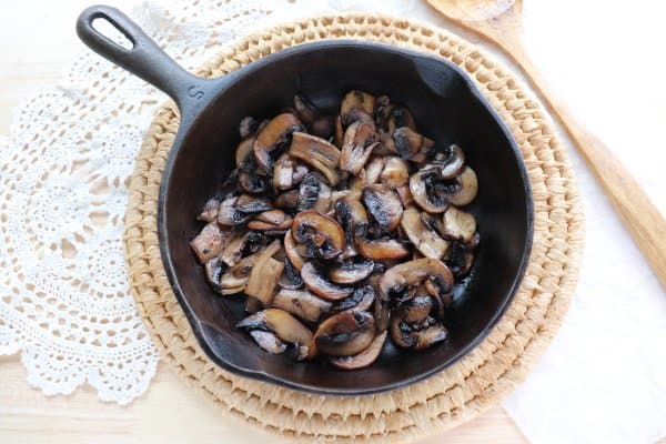 skillet philly cheesesteak recipe Sliced white mushrooms fried in a cast iron skillet.