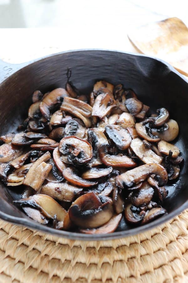 skillet philly cheesesteak recipe Sliced white mushrooms fried in a cast iron skillet.