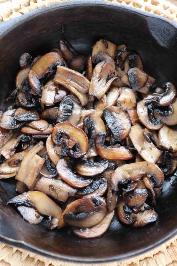 skillet philly cheesesteak recipe Sliced white mushrooms fried in a cast iron skillet.