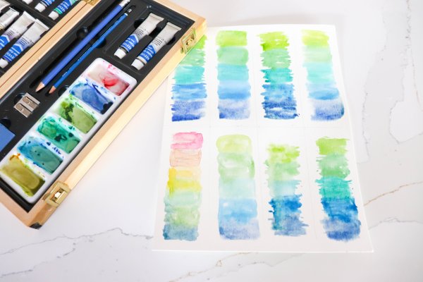 Eight sections of watercolor paper with blue, yellow, and green gradient painted.