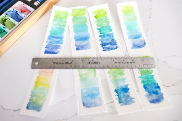 A ruler is used to tear along the section lines to create individual papers that are bookmark sized.