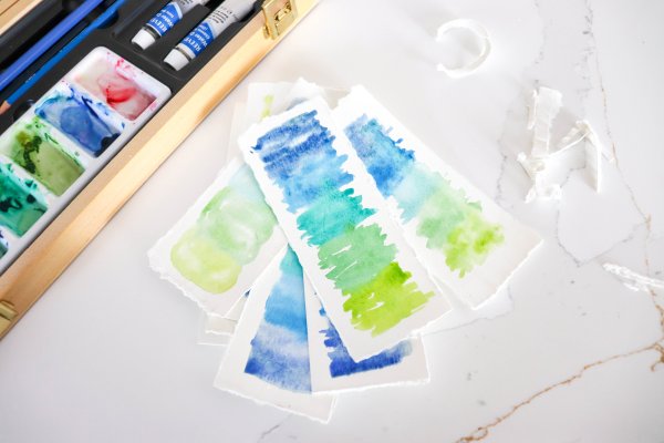 Eight pieces of painted paper to create watercolor bookmarks.