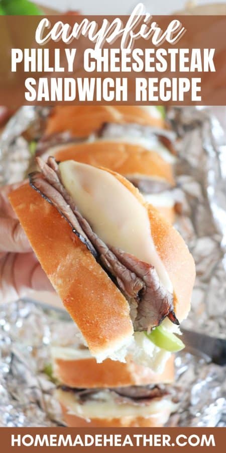 Campfire Philly Cheesecake Sandwich with green bell pepper, roast beef and melted white cheese between slices of french bread held in a hand.