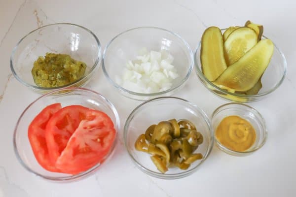 Chicago Style Hot Dog Ingredients in clear glass bowls.