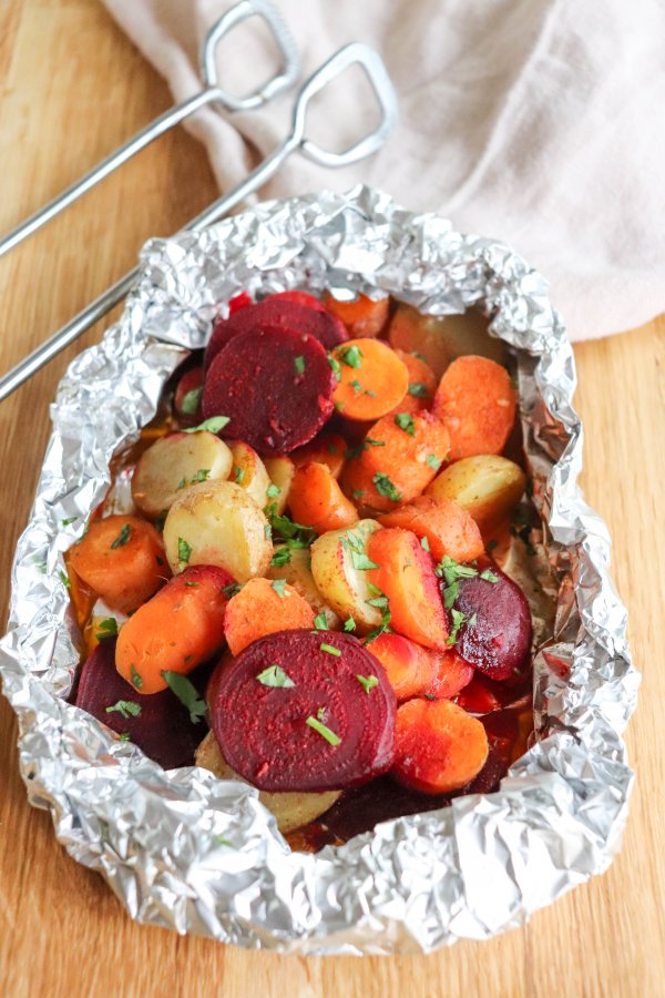 Rounds of beets, white potatoes and carrots cooked in a foil packet and topped with fresh parsley.