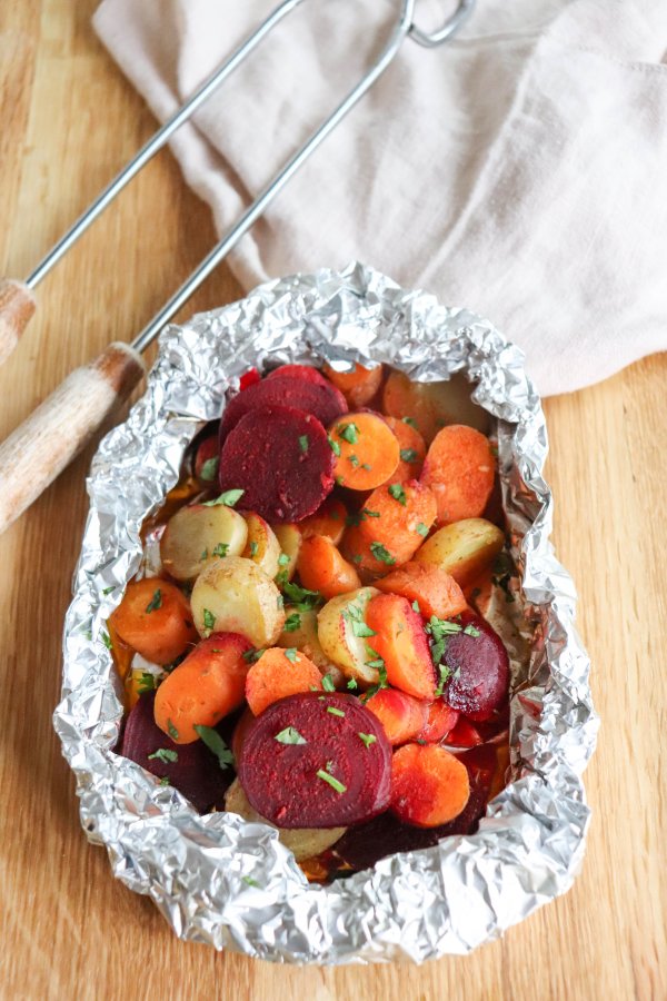 Rounds of beets, white potatoes and carrots cooked in a foil packet and topped with fresh parsley.