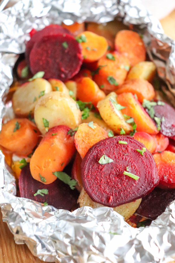 Rounds of beets, white potatoes and carrots cooked in a foil packet and topped with fresh parsley.