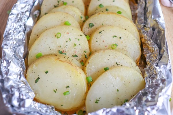 Sliced and seasoned potato and onion foil packs.