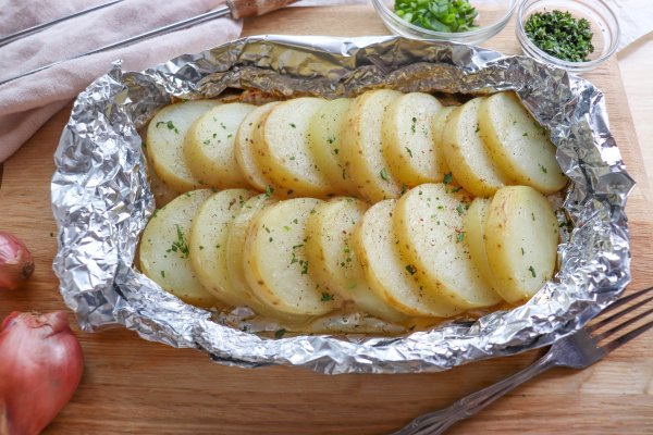 Sliced and seasoned potato and onion foil packs.