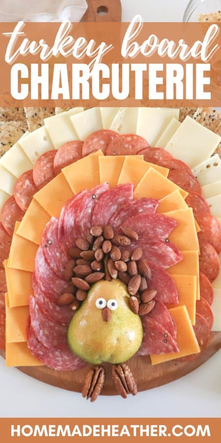 A meat and cheese charcuterie board in the shape of a turkey with a pear body and meat, cheese and cracker feathers.