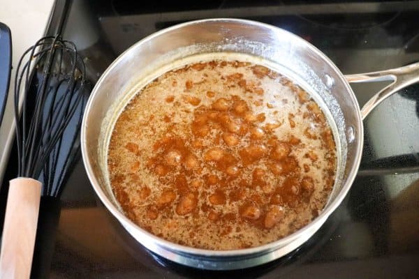 Butter and brown sugar melted together in a pot on the stove.