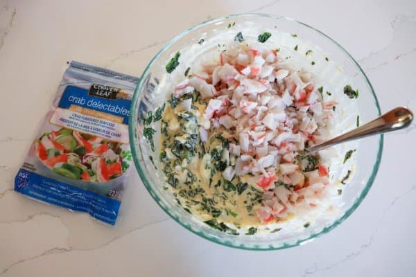 Crab filling in a medium bowl on a white counter.