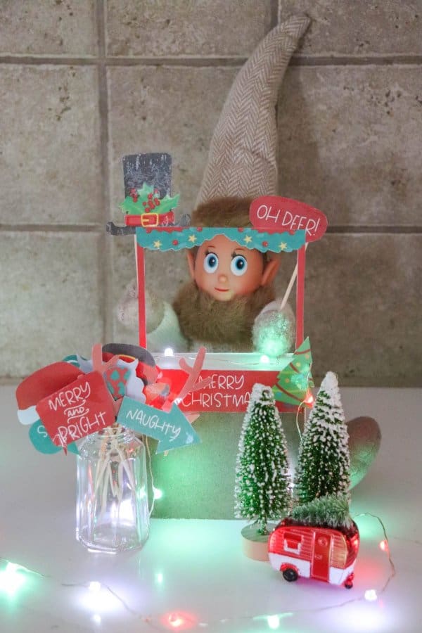 An Elf on the Shelf is holding printable photo props.