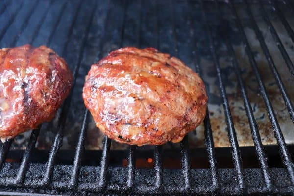 Hamburger patties on the grill grates of a BBQ.