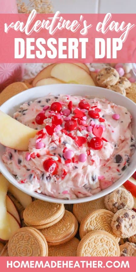 Valentine's Day dessert dip recipe is displayed in a bowl surrounded by apple slices, vanilla cookies, and small chocolate chip cookies.