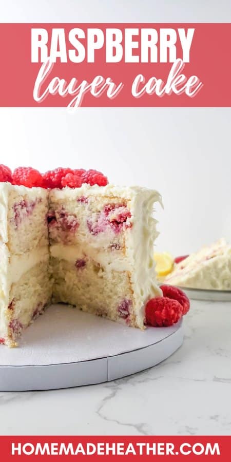 Two layer raspberry cake, iced and topped with fresh raspberries.