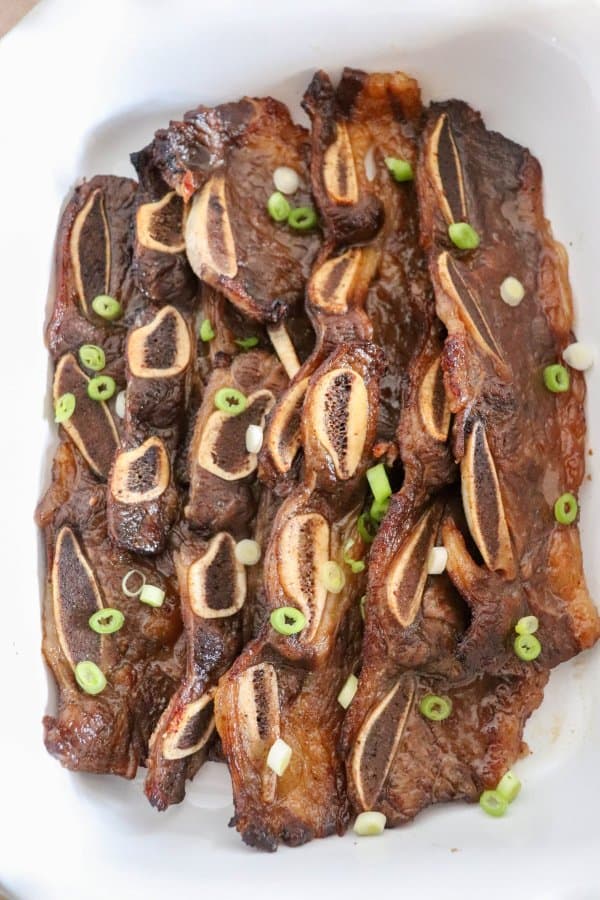 Short ribs that have been baked and garnished with green onions.