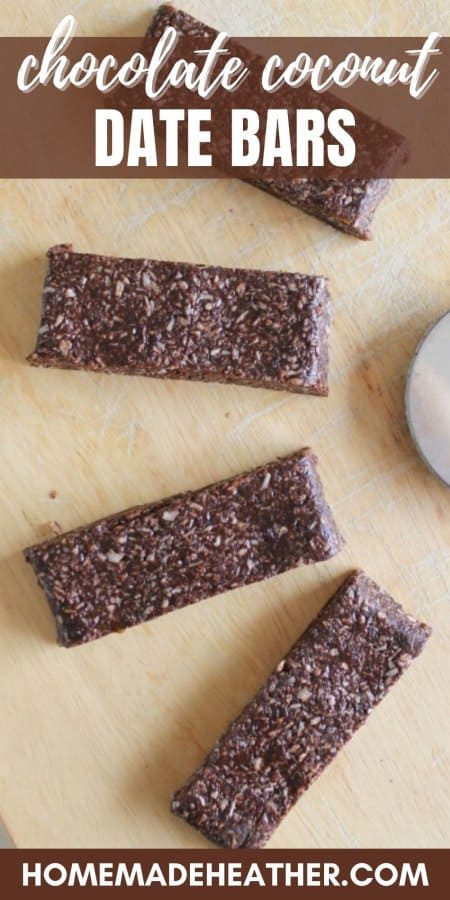 Four chocolate coconut date bars on a wooden surface.