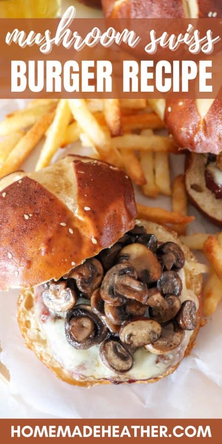 Sauted mushrooms on top of a burger with melted swiss cheese between a pretzel bun surrounded by fries with a mug of beer in the background with a text overlay.