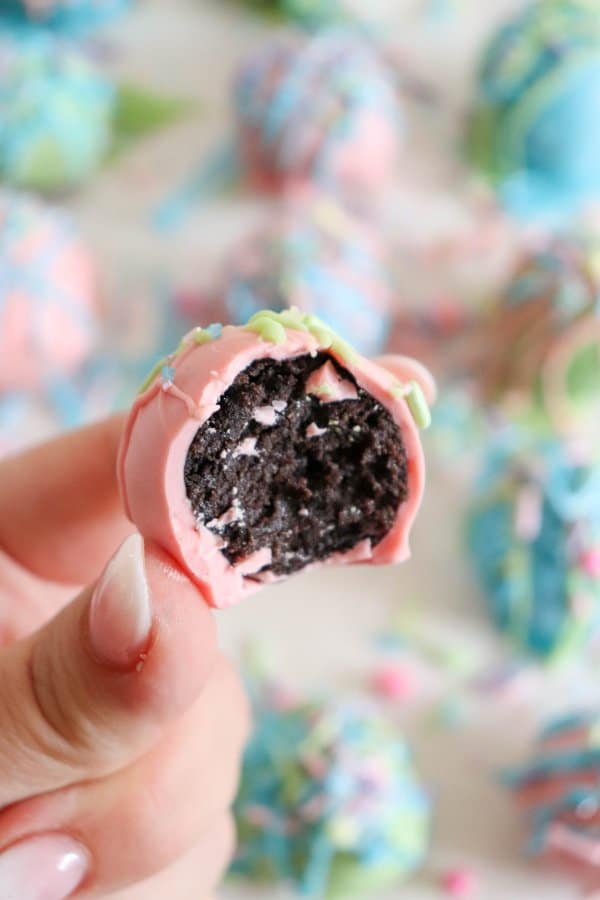 Oreo ball covered in pink chocolate with a bite taken out of it.