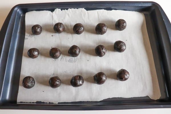 Oreo balls on a parchment paper lined cookie sheet.