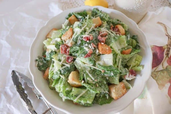 Finished classic Caesar salad recipe with croutons, bacon bits, and shredded parmesan cheese.