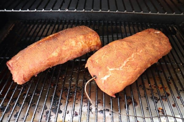 Traeger Pulled Pork Processing on the grill with a meat probe in the meat.