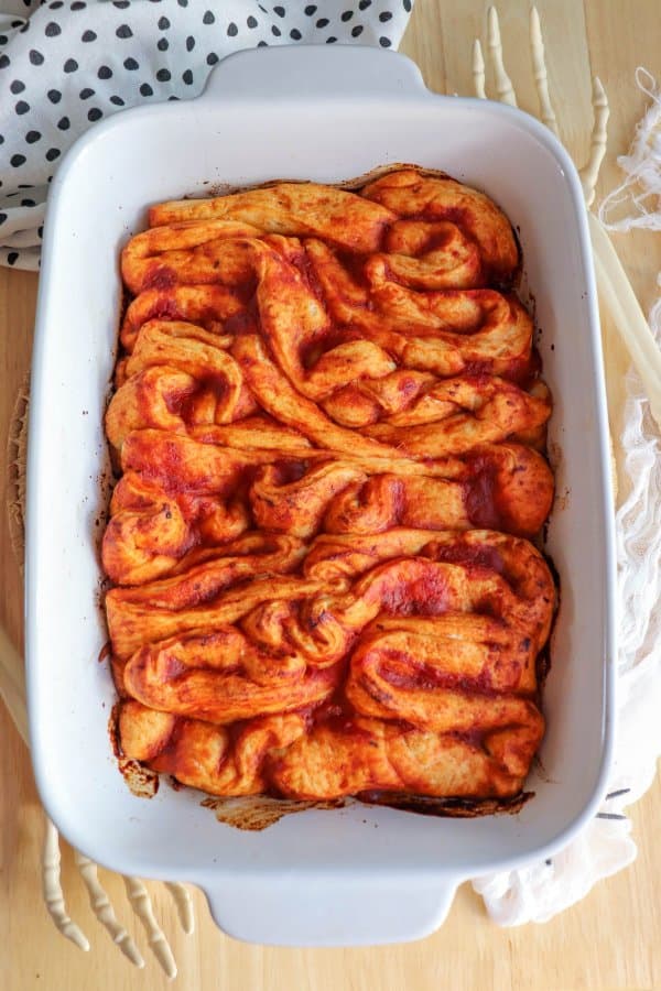Pizza in the shape of intestines in a white casserole dish.