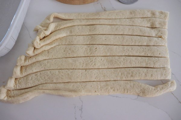 Halloween Deep Dish Pizza Process of dough being cut into strips.