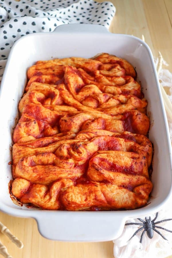 Pizza in the shape of intestines in a white casserole dish.